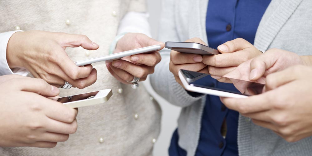 small group of people using cellphones together